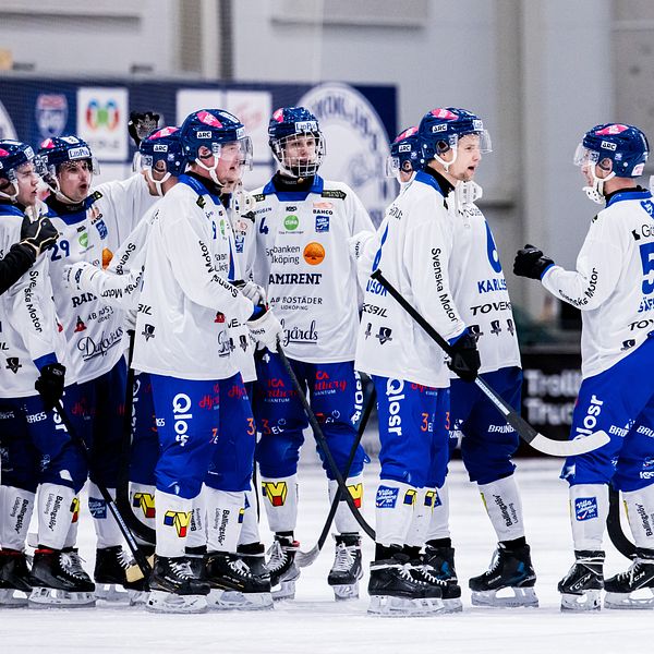 Spelare i vita tröjor tackar varandra efter matchen