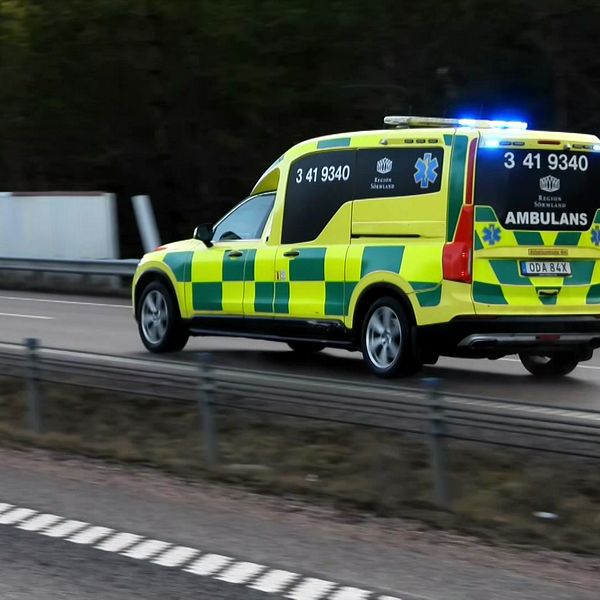 Ambulans med blåljus kör i hög hastighet på en landsväg.