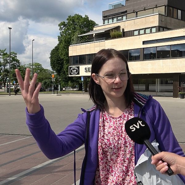 Kvinna viftar med armen på torget i Ljungby