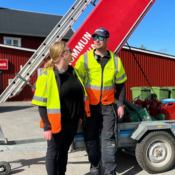 Carolina och hennes sambo Per-Arne står framför en röd släpvagn full med räddningsutrustning. De har reflexvästar på sig och står utanför affären i Överturingen.