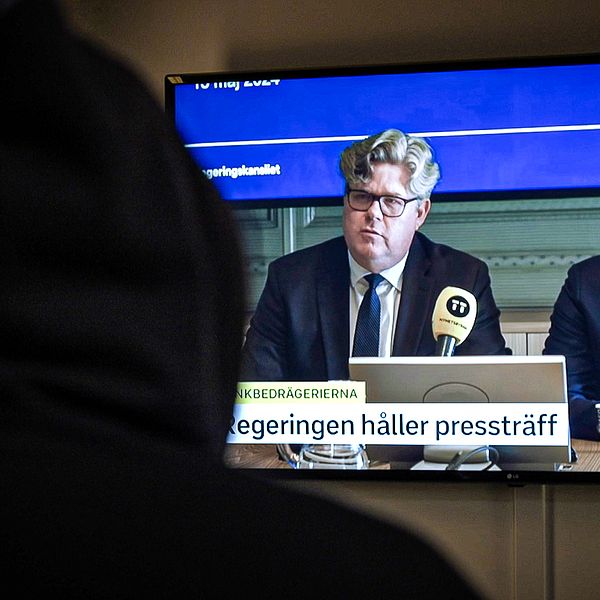 hackaren tittar på presskonferensen om bankernas förslag för att stoppa bedrägerierna