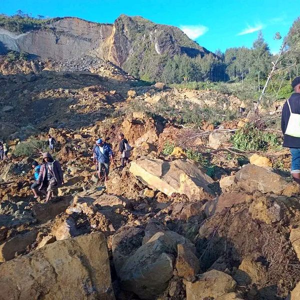 Människor går omkring bland rasmassorna efter en jordbävning i Paua Nya Guinea.
