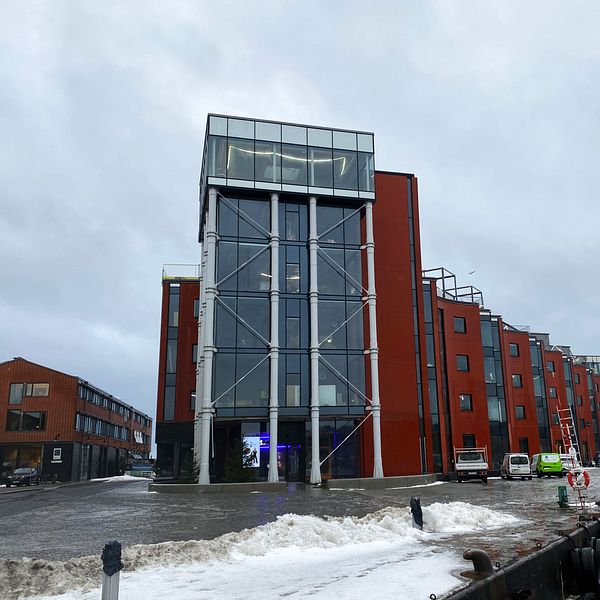 Bild på byggnad med glastorn och röd fasad vid havet. Byggnaden ligger på Östra Piren i Karlshamn.