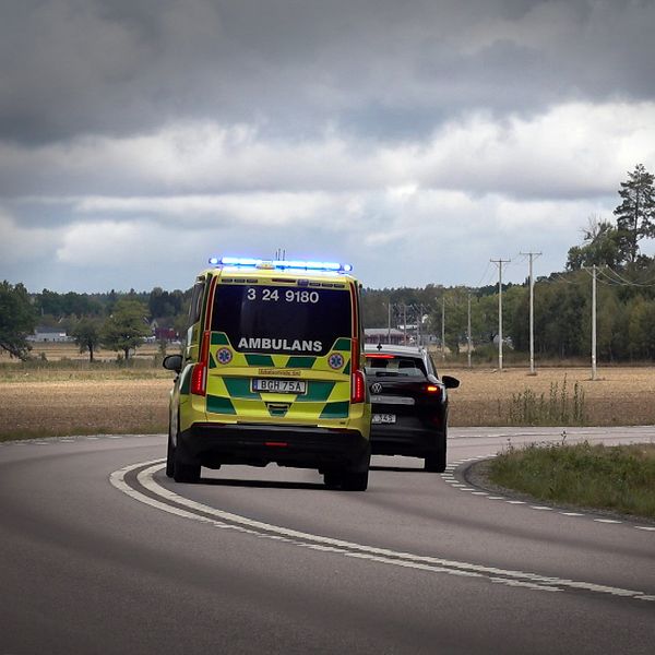 En ambulans under utryckning försöker köra om en bil.