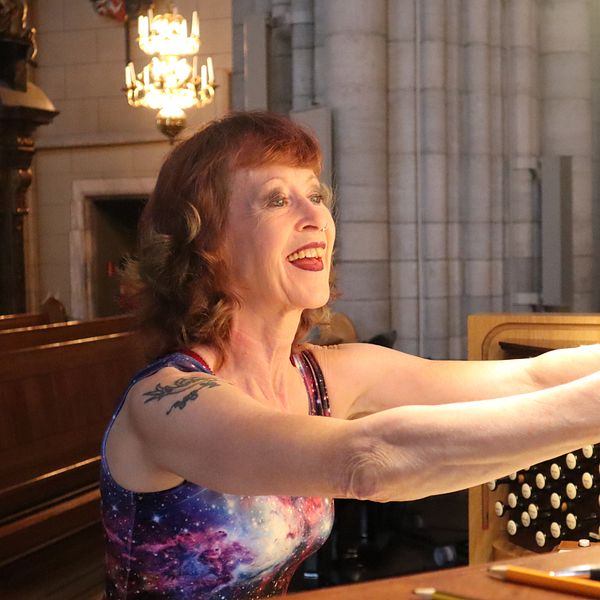 Ulla Olsson läser noterna framför orgeln.