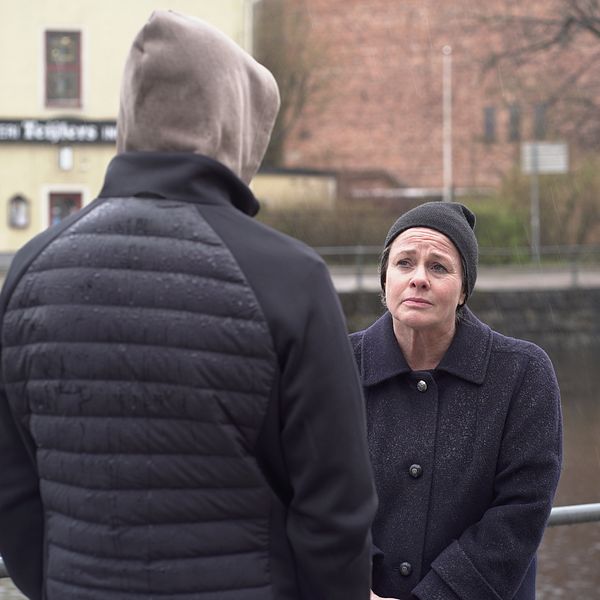 En anonym man och en kvinna står framför en å.
