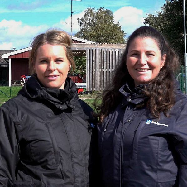 Två förskollärare utomhus i Eda med deras nya arbetsjackor.