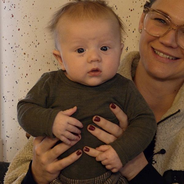 Christine Andersson sitter med sonen Frans i famnen på öppna förskolan i Vansbro.