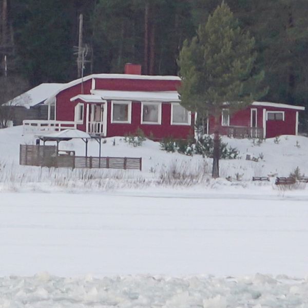 En röd stuga omgiven av snö på en sjö med träd i bakgrunden, samt en närbild på en kvinna med ett smycke på halsen, sittande framför en dekorerad bakgrund.