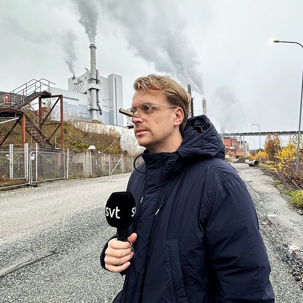 En reporter står med en klämma på näsan. Han är vänd åt sidan.
