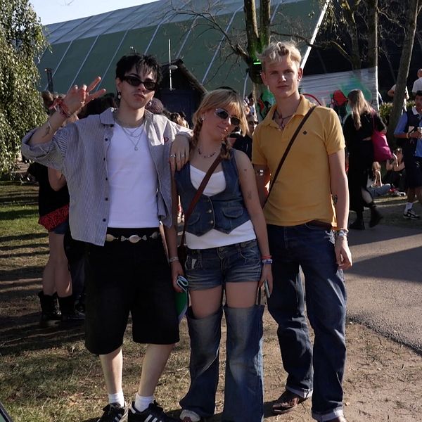 Tre personer poserar i festivaloutfits utomhus på Way out west-festivalen.