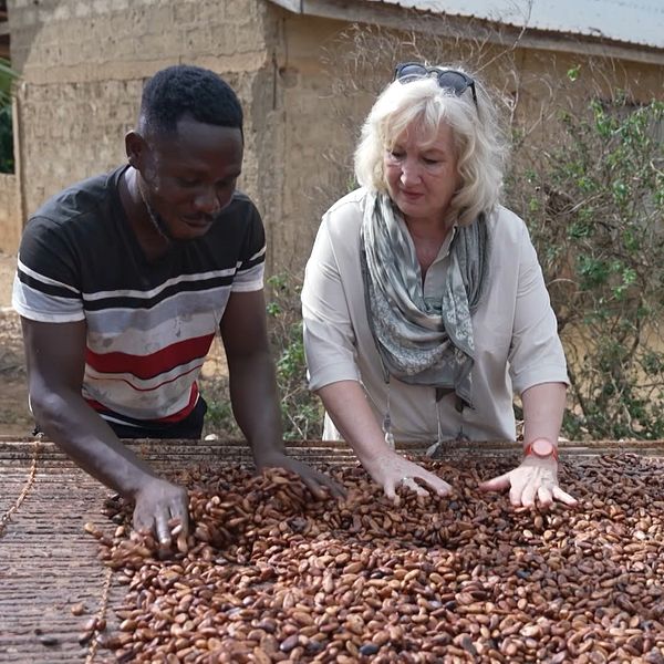Opoku Gyemfi Ahafo och Erika Bjerström drar händerna över kakaobönor