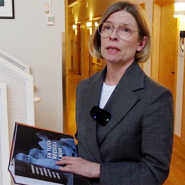 Birgitta Bergvall-Kåreborn, rektor Luleå tekniska universitet, håller i en bok och tittar mot kameran. Hon är klädd i en grå dräkt.