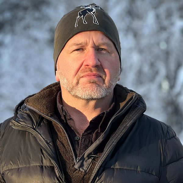 Martin Trostemo, viltsamordnare hos polisen står längs en vinterväg i Östersunds kommun med mössa och vinterjacka.