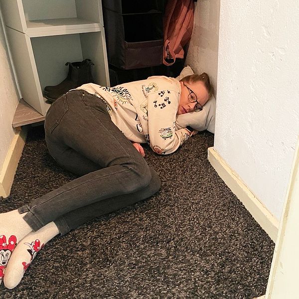 Kvinna ligger på golvet i en garderob.