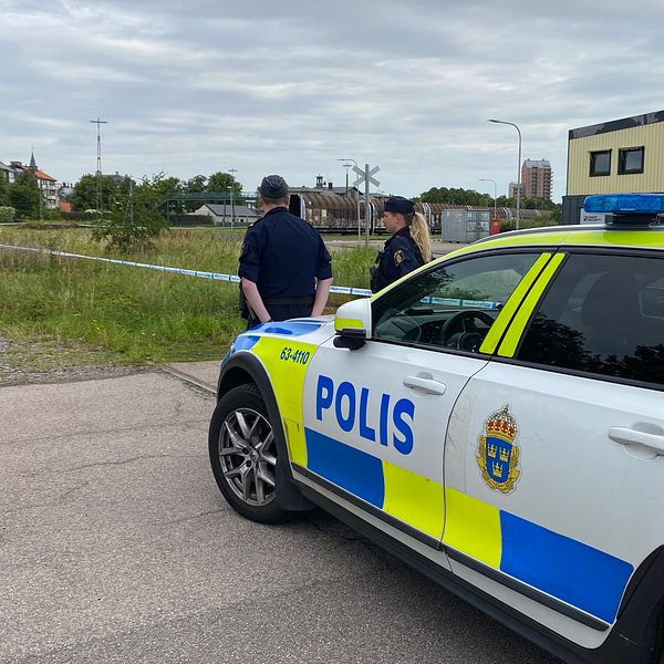 Två poliser övervakar avspärrningarna vid järnvägsstationen i Landskrona där en död kvinna hittats. Polisen misstänker mord.