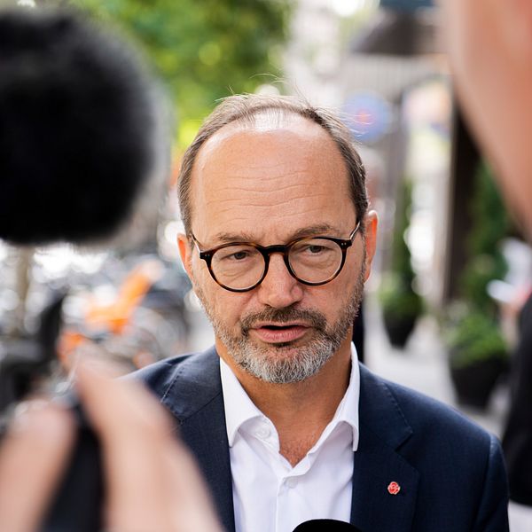 Intervju på gata mellan man i kostym och journalist med mikrofon.