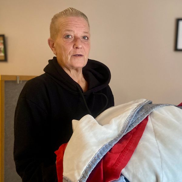 Carola Karlsson, husmor på Hudiksvalls natthärbärge, håller några sängkläder i famnen