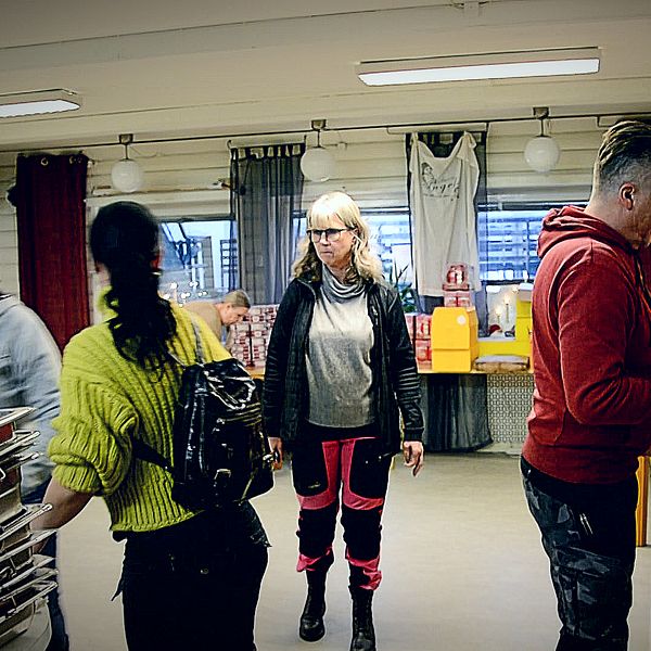 Folk som packar kassar med pepparkakor och bröd i en lokal