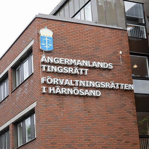 Fasad av byggnaden för Ångermanlands tingsrätt och Förvaltningsrätten i Härnösand, med röd tegelvägg och skylt med juridiskt emblem.
