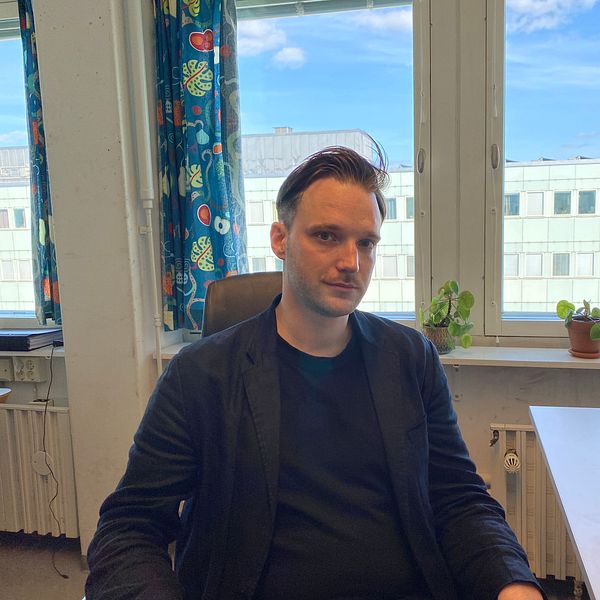En bild på Zeth Isaksson när han sitter i sin kontorsstol framför sina fönster i sitt kontor.