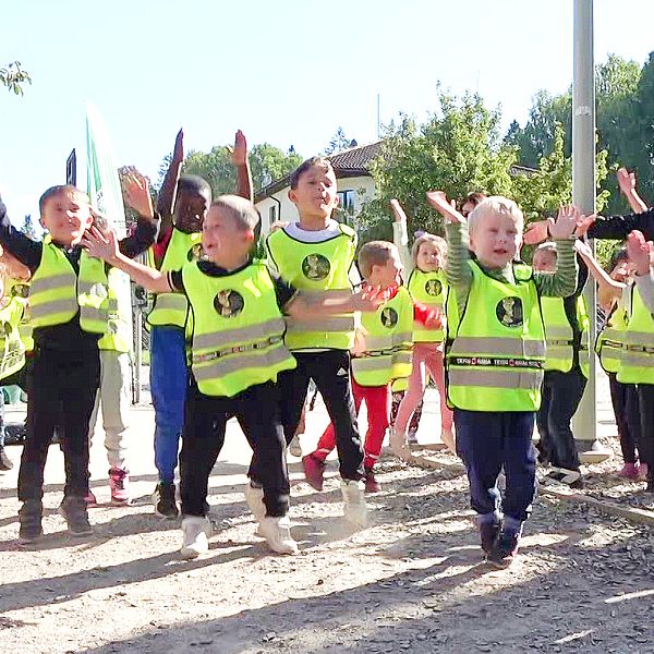 Barn i gula västar hoppar på förskolan i Kaxberg Södertälje
