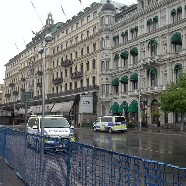 Två polisbilar står parkerade på en avspärrad gata framför ett hotell i centrala Stockholm.