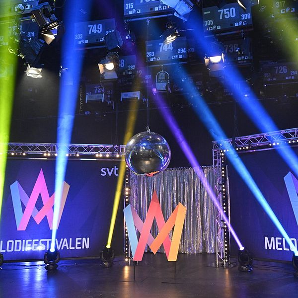 Scen med strålkastare och stora dukar med texten Melodifestivalen