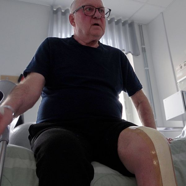 Jan Berman sitter med nyopererat knä på en sjukhussäng.