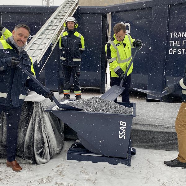 Statsministern och chefer på SSAB lastar över järnsvampen Hybrit på ett rullband.