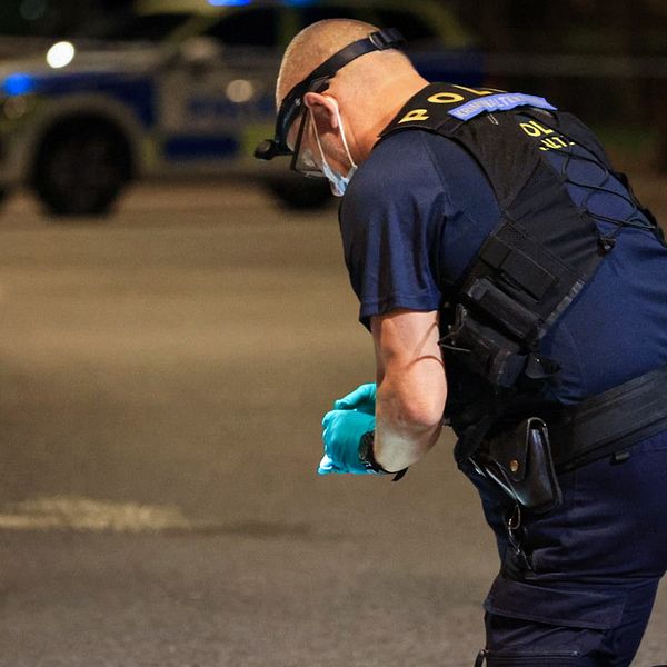 En polis undersöker en brottsplats utomhus i Uppsala.