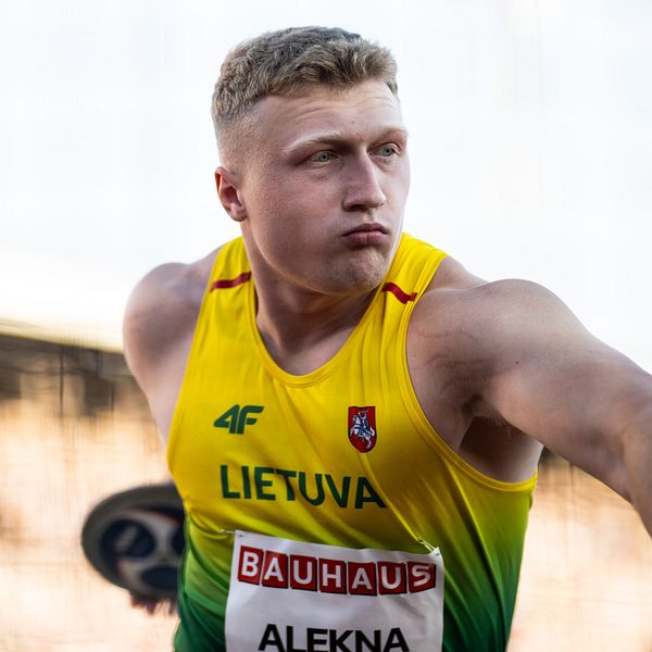 Discus thrower in Lithuanian jersey preparing for a throw.
