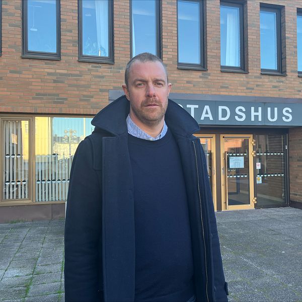 En man framför stadshuset i Vimmerby.