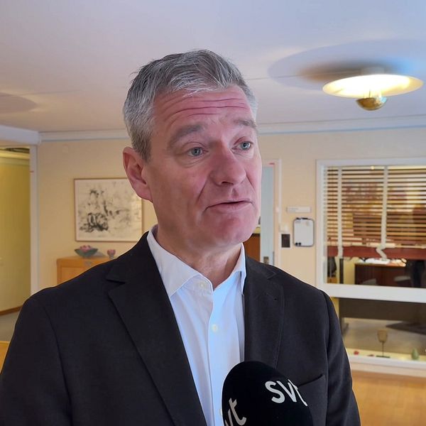 Rickard Simonsson, regiondirektör i Örebro län, syns stående i kontorsmiljö i halvkroppsbild med en mikrofon framför sig.