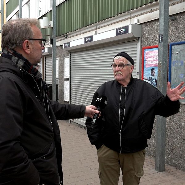 Leif Holmberg visar SVT:s reporter Jens Larson stängda butiker i Jordbro centrum.