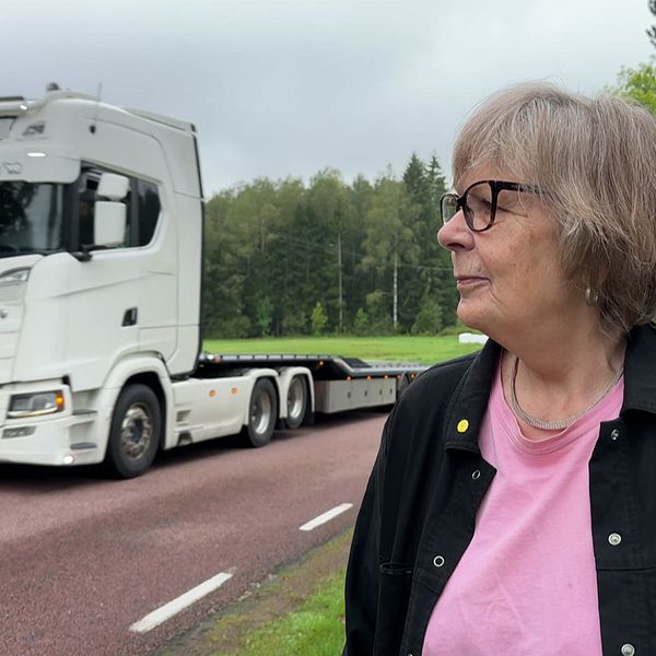 Annika Amnelind vid länsväg 669 med en lastbil passerande i bakgrunden.