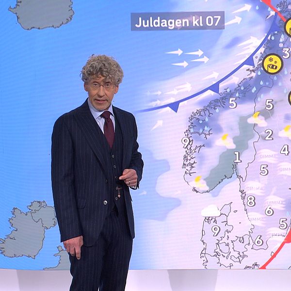 Väderprognos för juldagen, med en meteorolog som presenterar temperaturen och väderförhållandena över Sverige och delar av Norden. Vädret visas med symboler för sol, moln och snö, samt en temperaturskala.