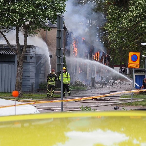 Brandmän vid det nedbrunna huset