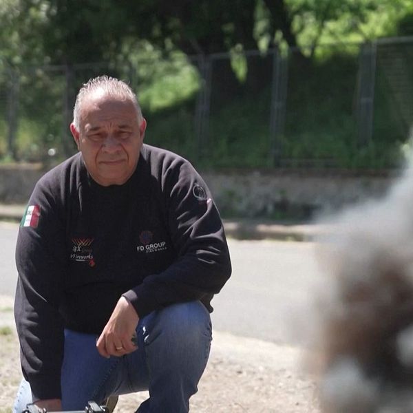 En person hukar utomhus intill en stig med rökmoln i förgrunden.