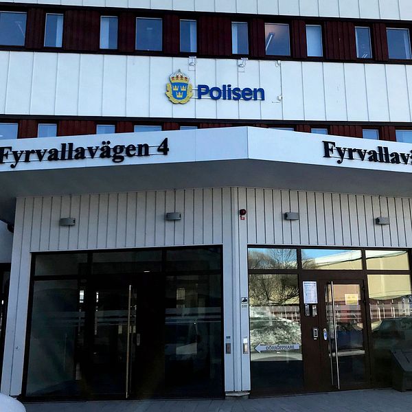 Entrén till polishuset vid Fyrvallavägen 4, med polisens logotyp ovanför ingången.