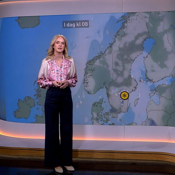 SVT:s meteorolog framför väderkarta med gul varning i Östergötland.