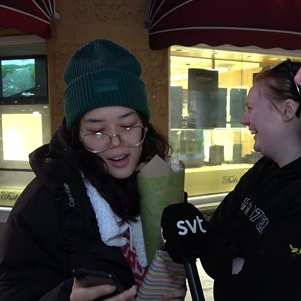 Luleåborna Malisa Songsuwan och Elina Gustavsson tittar på en bild i telefonen som SVT:s reporter Elias Paulsson visar.