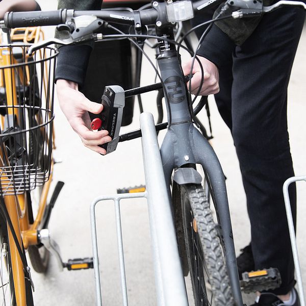 Person som låser cykel med bygellås.