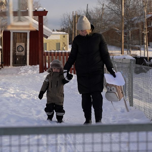 Förälder och barn utanför förskola