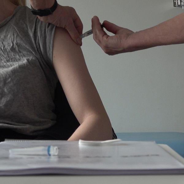 En kvinna blir vaccinerad, ett stick i armen
