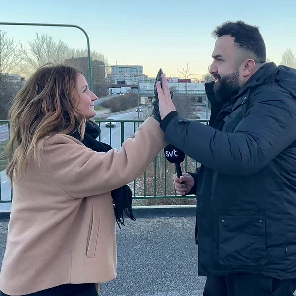 Fanny Berg och Hamza Ftouni gör high five på en bro över trafikerad gata.