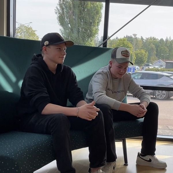 Två killar sitter i en soffa