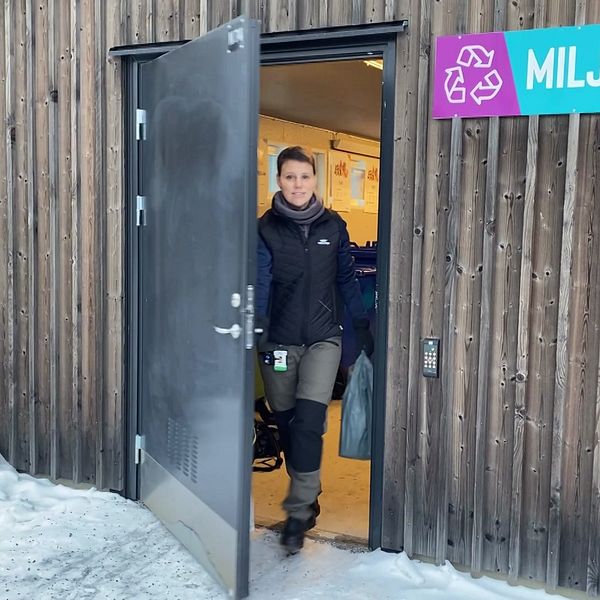 Kvinna som går ut ur ett soprum.