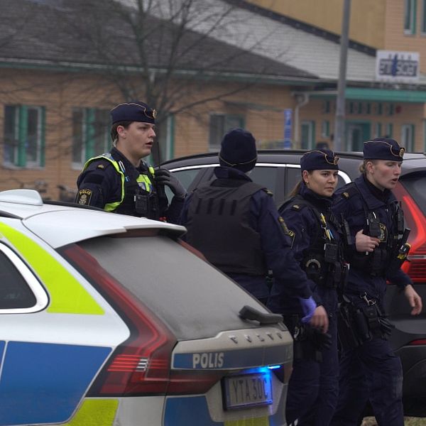 Poliser intill en polisbil utanför Risbergska skolan i Örebro, platsen där Rickard Andersson mördade tio personer i Sveriges värsta masskjutning genom tiderna.