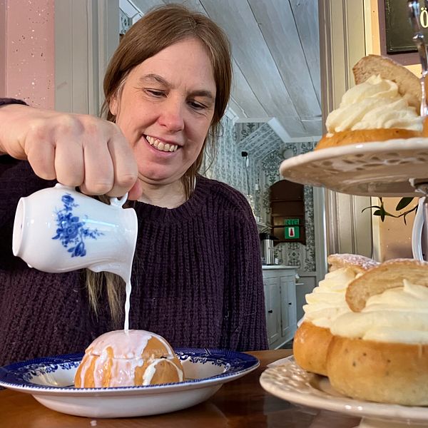 kvinna häller hetmjölk över en semla